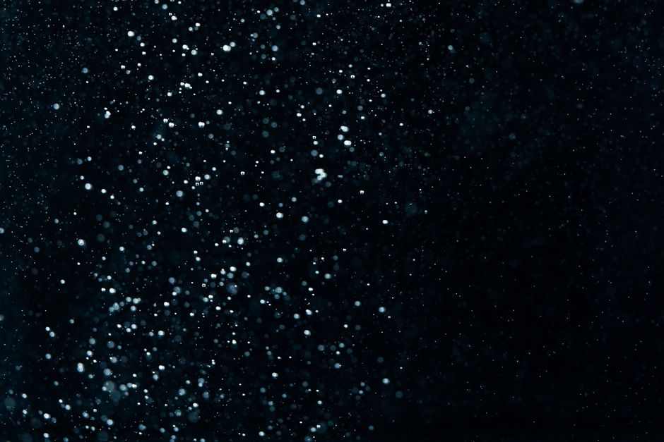 Abstract image of water droplets resembling a starry night sky with a dark backdrop.