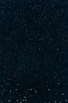 Captivating abstract starry night sky with sparkling particles in a dark background.