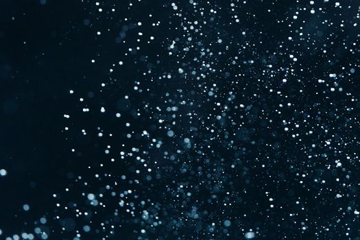 Captivating close-up of water droplets and particles against a dark background, creating an abstract visual effect.