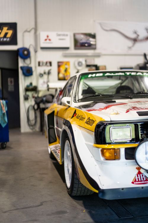 Free Close-up of a classic rally car in a workshop garage, showcasing retro racing design. Stock Photo
