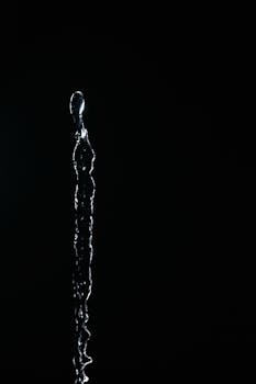 Captivating high-speed capture of vertical water splash against dark background.