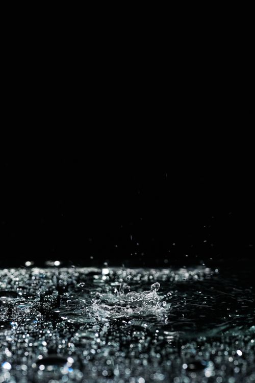 Free Capture of water droplets splashing on a reflective surface with a black background. High-speed photography at its best. Stock Photo