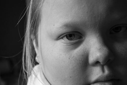 Free A detailed grayscale close-up of a child's face highlighting freckles and expressions. Stock Photo