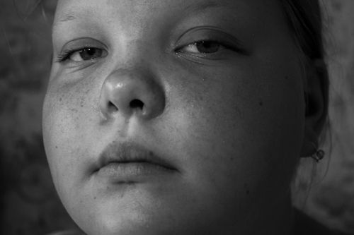 Free Close-up black and white portrait of a serious, freckled child. Captures deep emotion. Stock Photo