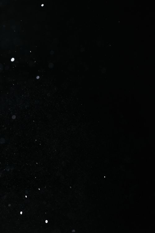 Free Dark black background adorned with floating particles creating a mysterious effect. Stock Photo