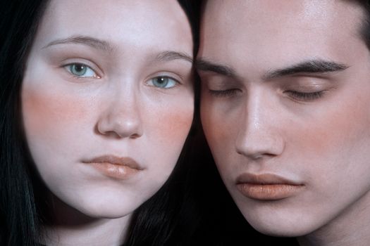 Intimate close-up portrait of a couple with soft lighting, capturing a pensive mood.