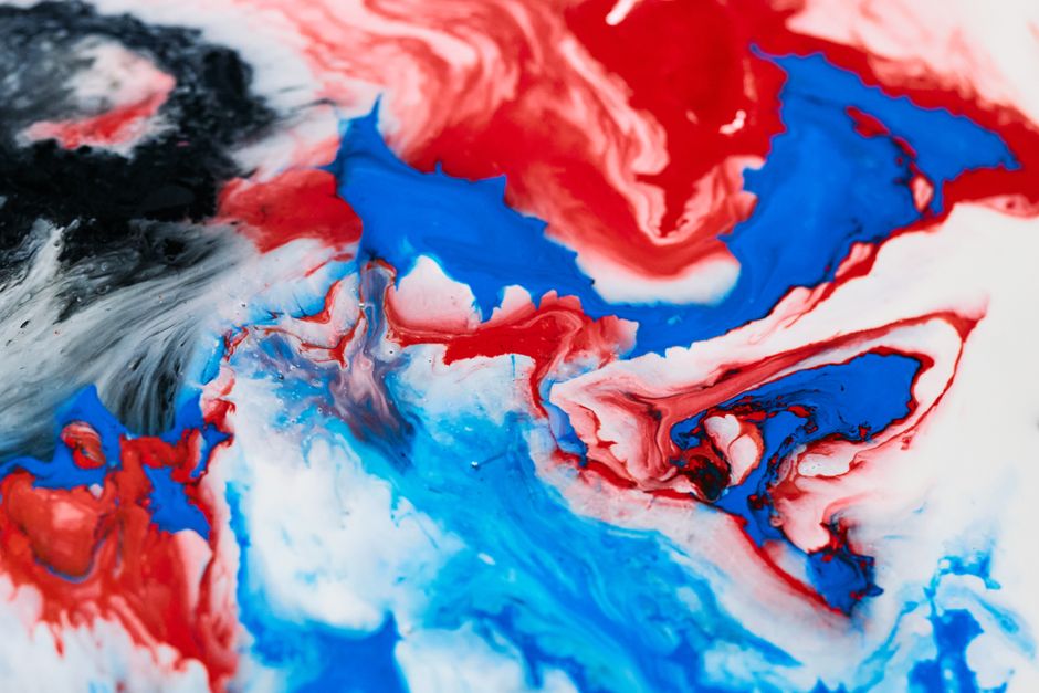 Colorful abstract art with swirling red, blue, and black pigments.