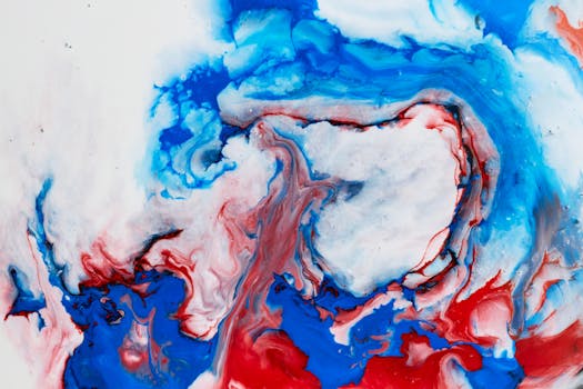 Dynamic abstract artwork with swirling red and blue acrylic colors creating a vivid visual effect.