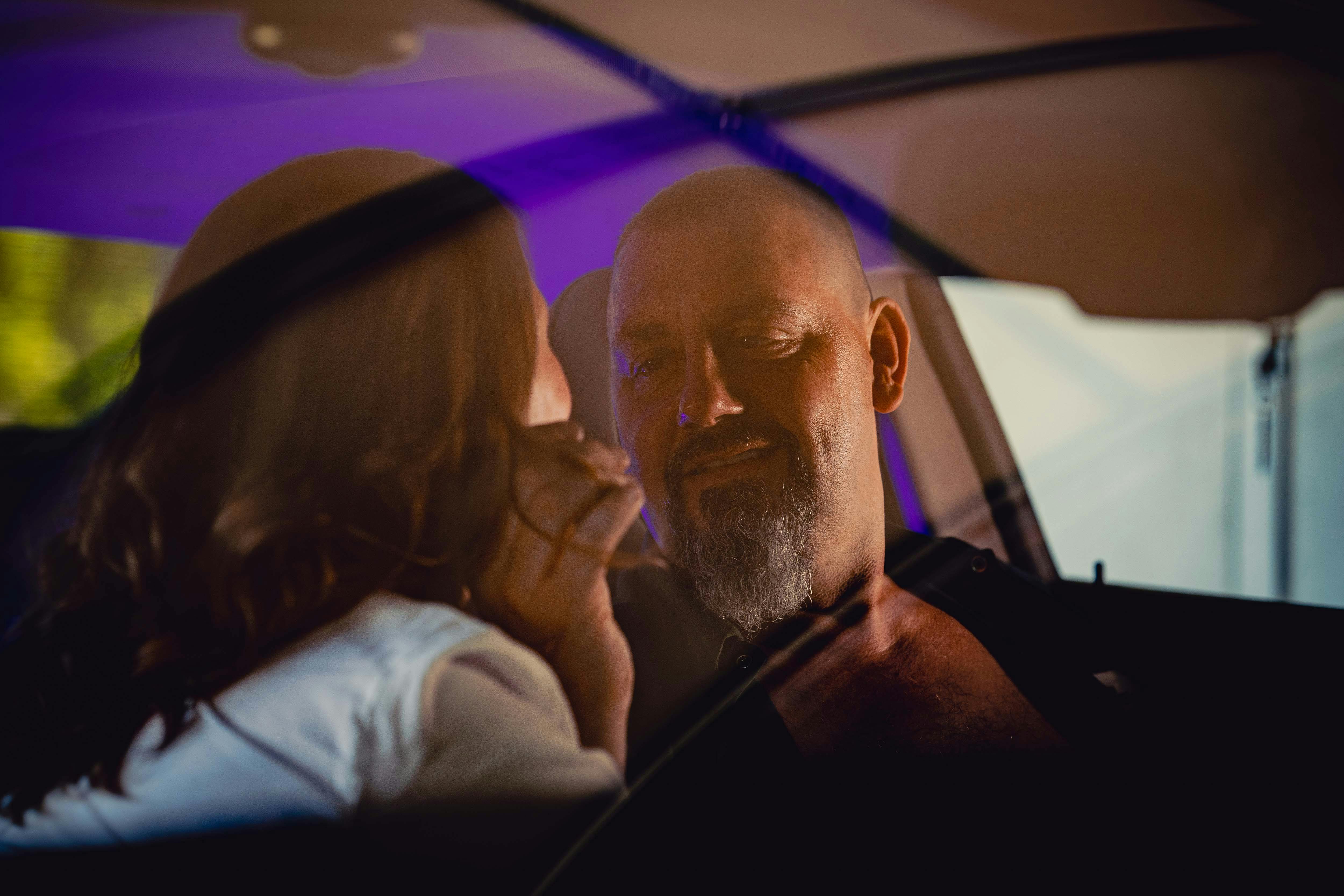 A tender moment between a couple inside a car, capturing love and connection.