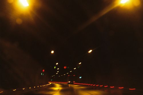 Free Blurred lights reflecting on a wet road during nighttime drive through a highway tunnel. Stock Photo