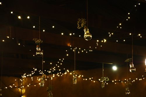 Guirlande lumineuse et bocaux suspendus créant une ambiance chaleureuse pour un apéro en intérieur