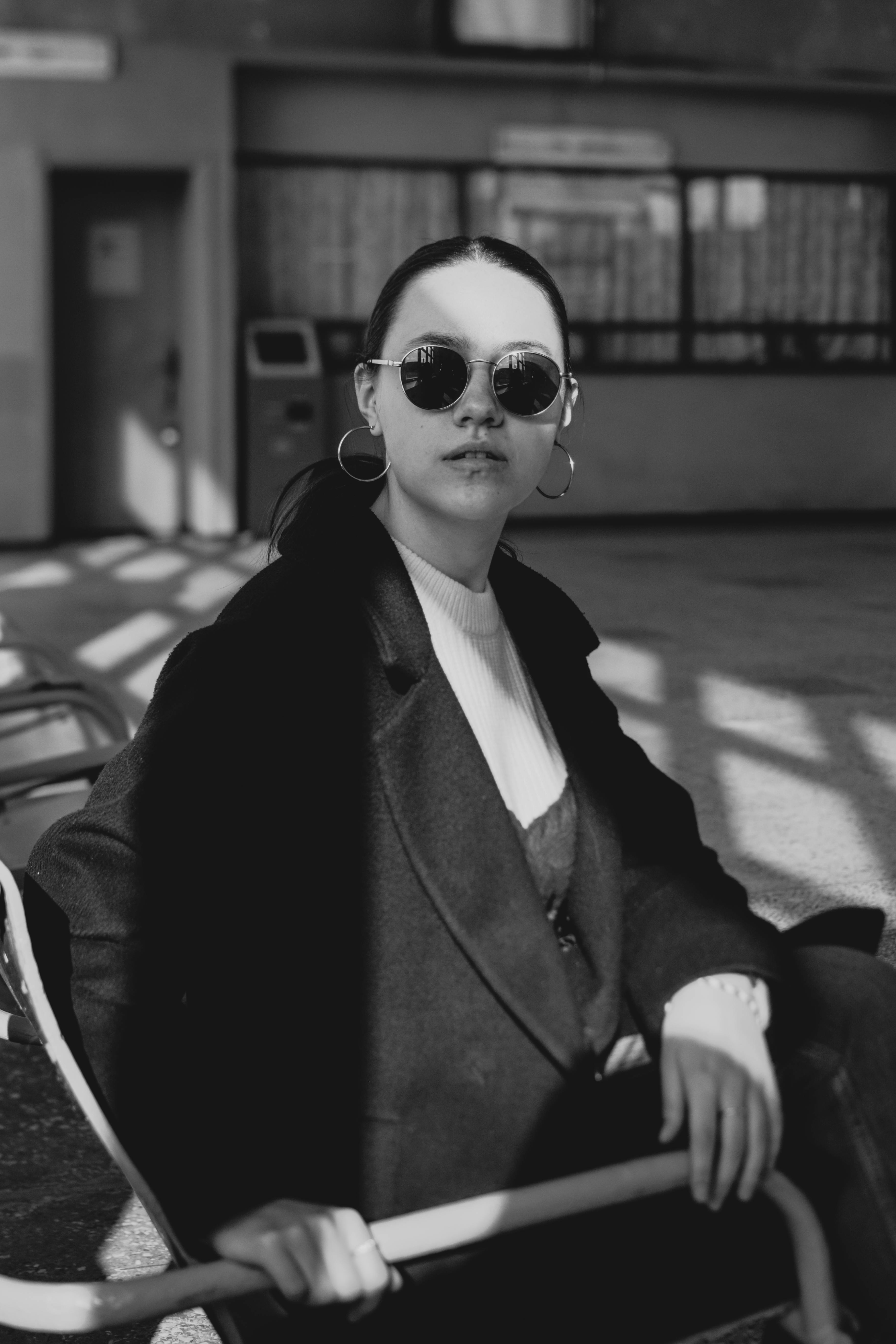 Black and white picture of young woman sitting on chair · Free Stock Photo