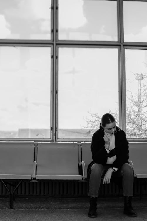 Free A Woman Sitting on a Waiting Area Stock Photo