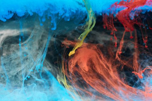 A dynamic display of colorful ink swirling in water, showcasing vibrant hues and artistic textures.