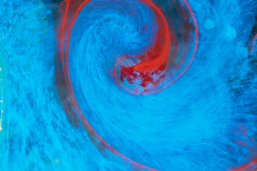Dynamic abstract swirl of blue and red colors, resembling fluid motion.
