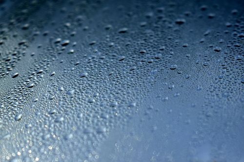 Free Detailed close-up of water droplets on a blue glass surface, showcasing texture and pattern. Stock Photo