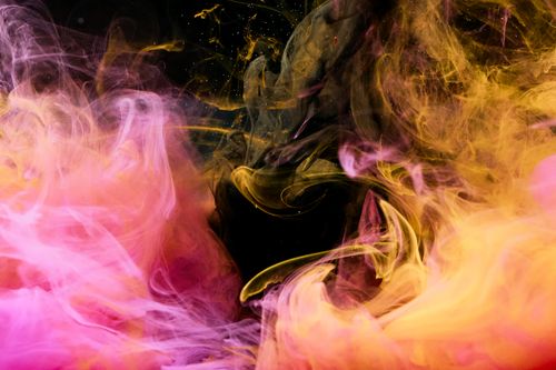 Free Dynamic abstract ink swirl with pink and yellow hues creating a vibrant effect. Stock Photo