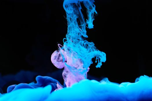 Dynamic blue and purple ink swirls create a captivating abstract visual with a striking contrast against a dark background.