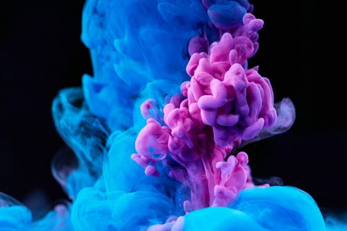 Free Dynamic high-speed photography capturing pink and blue ink swirling in water. Stock Photo