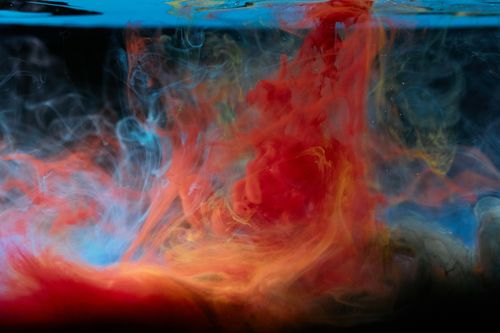 Free Vibrant red and blue ink swirling in water creating an abstract visual effect. Stock Photo