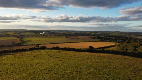Free Aerial view showcasing Sharpenhoe, England's sprawling rural fields and picturesque countryside under a blue sky. Stock Photo