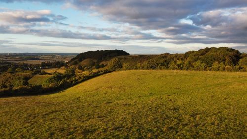Free Capture of the scenic English countryside in Sharpenhoe during a stunning sunset with lush green fields and rolling hills. Stock Photo