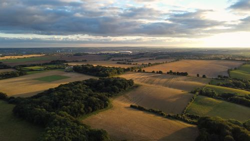 Free Aerial view of vast agricultural fields and countryside in Streatley, England during sunset. Stock Photo