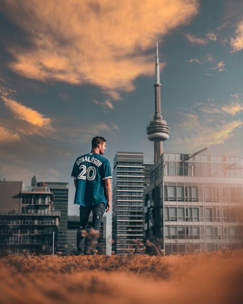 Free Man Standing Near The Cn Tower in Canada during Sunset Stock Photo