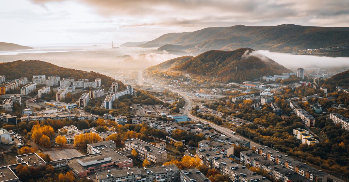 aerial view of Ho with morning mist over red rooftops and distant mountain
