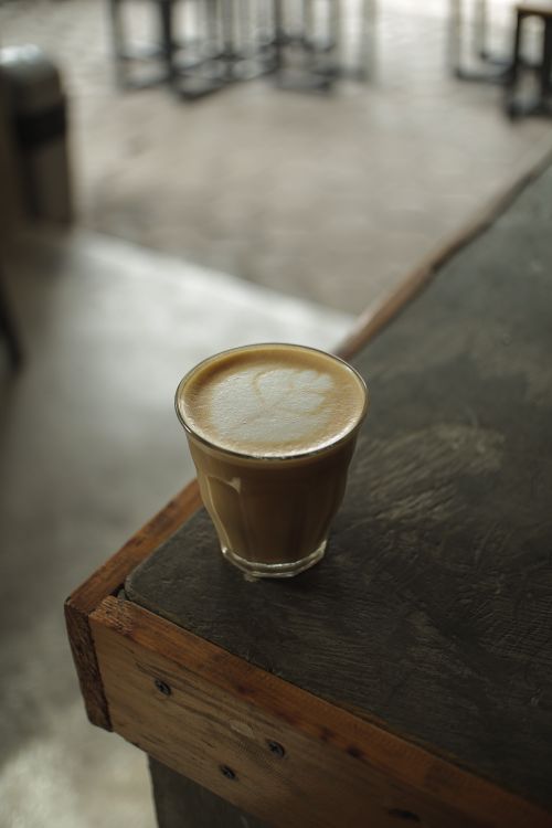 Free A glass of latte with delicate art in a cozy coffee shop atmosphere. Stock Photo