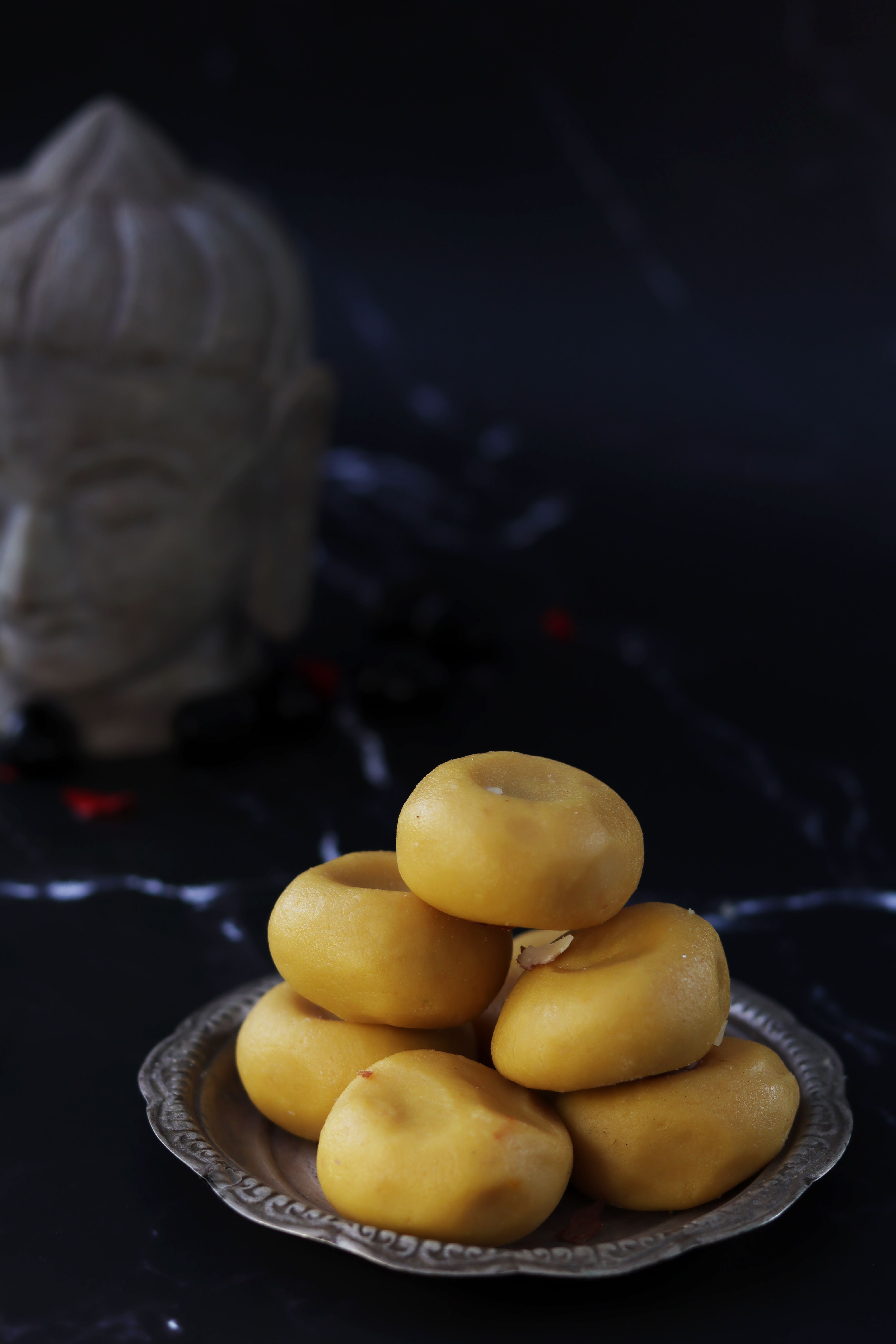 Sliced anjeer barfi on a wooden board alongside dried figs and cashews