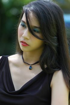 Beautiful outdoor portrait of a young woman with long hair and subtle makeup.