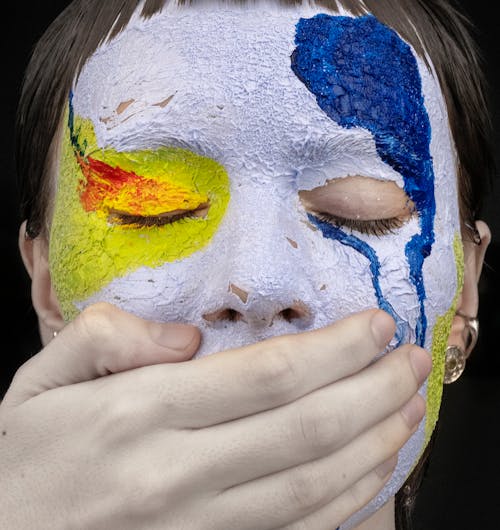 Free Hand Covering the Mouth of a Person with Face Paint Stock Photo