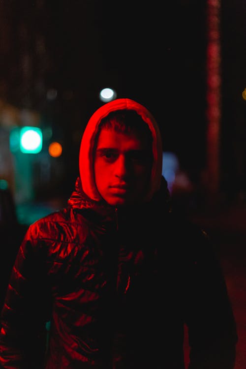 Free Man in a Jacket Being Illuminated by a Red Light Stock Photo