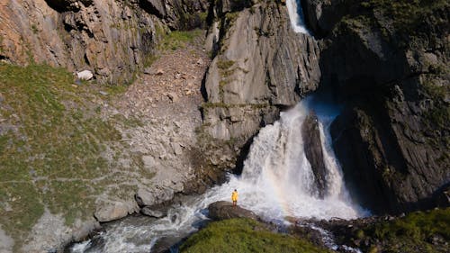 Person Standing on Rock Near Waterfalls