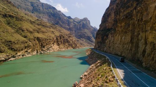 Free A stunning view of a mountain road beside a river in Dagestan, Russia, showcasing rocky landscapes and clear skies. Stock Photo