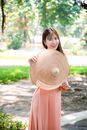 Woman in Pink Dress Holding Brown Hat