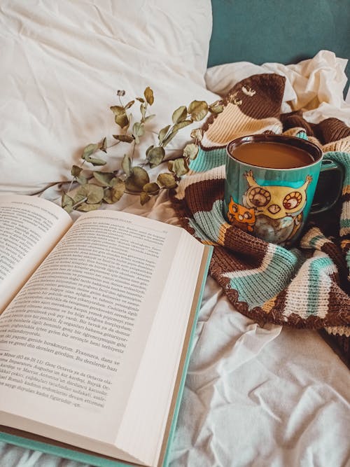 An Open Book near a Cup of Coffee