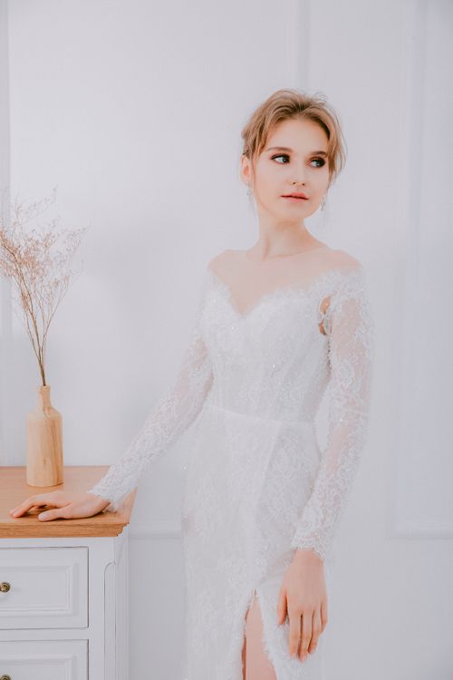Free A sophisticated bride in a lace wedding dress posing indoors, perfect for wedding photography themes. Stock Photo