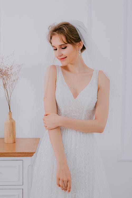 Free A Woman in White Sleeveless Wedding Dress and White Veil Stock Photo