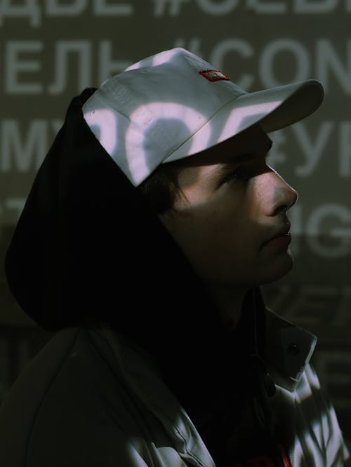 Close Up Photo of Man in Black Hoodie and White Hat