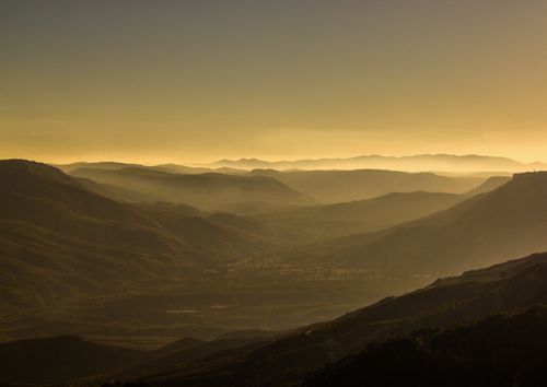 Free Captivating aerial view of misty mountain ranges during golden hour for serene landscapes enthusiasts. Stock Photo
