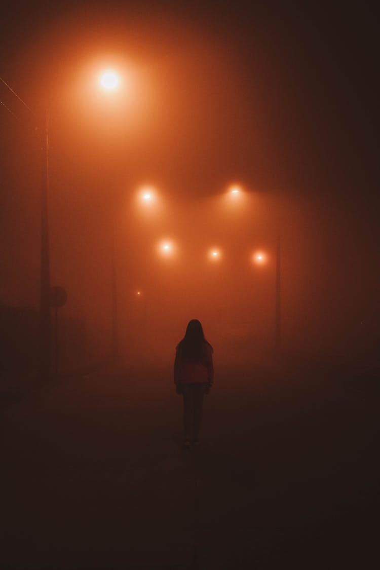 Woman Walking On Dark Street 