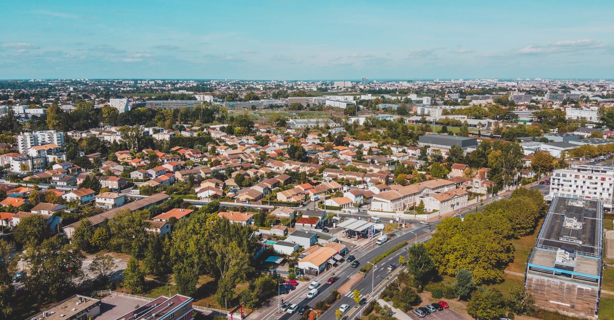 Aerial view of a residential area in Bordeaux, France, featuring houses, roads, and greenery.