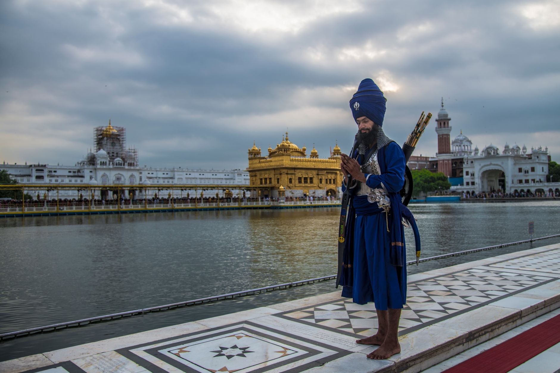 A Sikh warrior in traditional attire prays by the Golden Temple in Amritsar, India.
