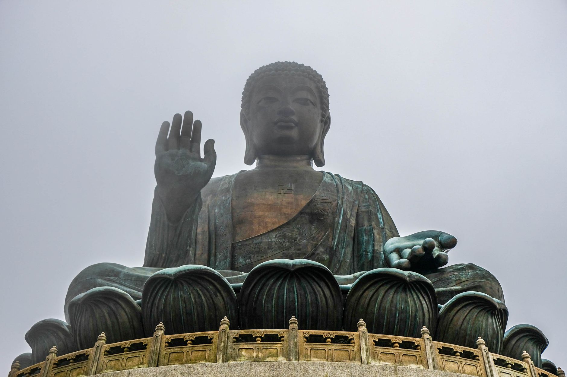 Majestic Tian Tan Buddha statue on Lantau Island, Hong Kong in misty weather seen from below. โ photo by Mike Tyurin / Pexels