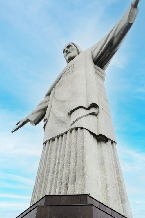 Free Iconic Christ the Redeemer statue captured from below against a clear blue sky in Rio de Janeiro, Brazil. Stock Photo