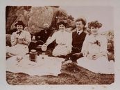 A charming vintage black and white photo depicting a group at a picnic.