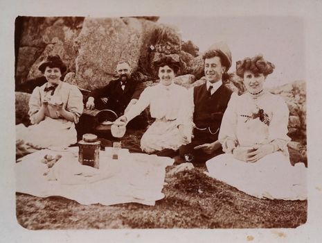 A charming vintage black and white photo depicting a group at a picnic.