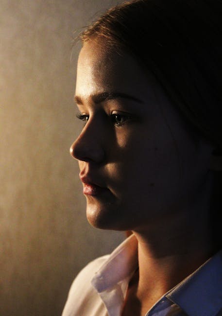 Artistic portrait of a woman with dramatic lighting creating a contemplative mood.